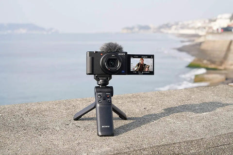Wireless Bluetooth Shooting Grip And Tripod For Still Photos And Video Perfect For Vlogging Cable Free Remote Commander Dust And Moisture Resistant Flexible Tilt Quick Direction Changes GP VPT2BT displayed on a ledge by the sea with a camera mounted
