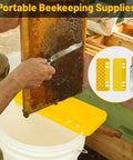 Beekeeping Uncapping Kit With Tank Holder And Plastic Scraper Tool Serrated Knife Set for Uncapping Honey Frames shown in use.
