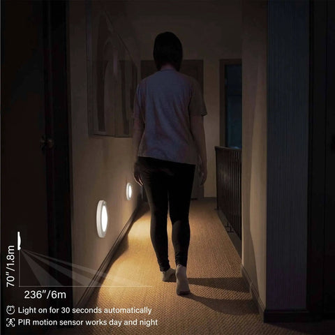 Person walking down a hallway illuminated by 6 Inch 120 Volt LED Closet Light With PIR Motion Sensor Ceiling Disc Light 15W 1100 Lumens CRI Over 80 Daylight White 5000K Wet Location ETL
