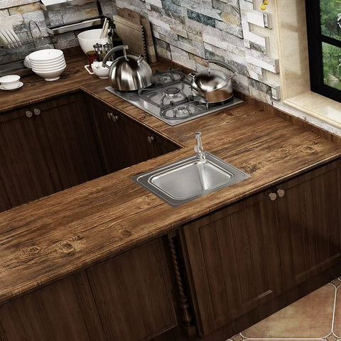 Kitchen countertop with brown wood grain contact paper peel and stick for cabinets and countertops, featuring a sink.