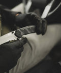Gloved hand holding Assisted Opening Tactical Knife With 9.3 Inch Overall Length, 4 Inch Tanto Blade, for outdoor use.