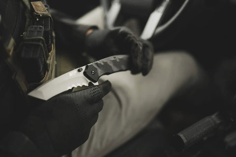 Gloved hand holding Assisted Opening Tactical Knife With 9.3 Inch Overall Length, 4 Inch Tanto Blade, for outdoor use.