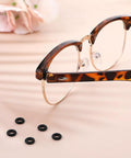 Six Piece Eyeglass Repair Kit With Glasses Temple Grips And Silicone Hinge Tighteners To Give Your Specs A Solid No Sweat Grip Plus Compact Screwdrivers For A Breeze Quick Fix That Works Like A Charm All Day, featuring tortoiseshell glasses and black silicone grips.