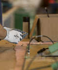 Worker wearing HyFlex 11-800 Nylon Glove With Gray Foam Nitrile Coating, Knit Wrist Cuff, Size 8 Medium, handling tools at workstation.