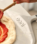 Ooni 12-inch aluminum pizza peel with black handle.