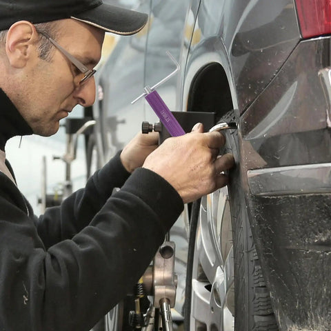 Mechanic using Thread Repair Kit With Zinc Alloy Inserts For Cars And Machinery on car wheel for thread restoration