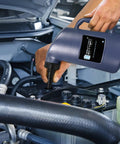 Auto Shut Off Battery Filler Jug For Golf Carts And Deep Cycle Batteries being used with fast flow valve in car engine bay.