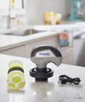 Versa Power Scrubber Grout Brush And Shower Cleaning Tool displayed on a kitchen countertop with pads and USB charger.
