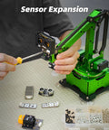 LewanSoul Robotic Arm Kit, side view with green frame; screwdriver in use, several circuit boards and hardware on table.