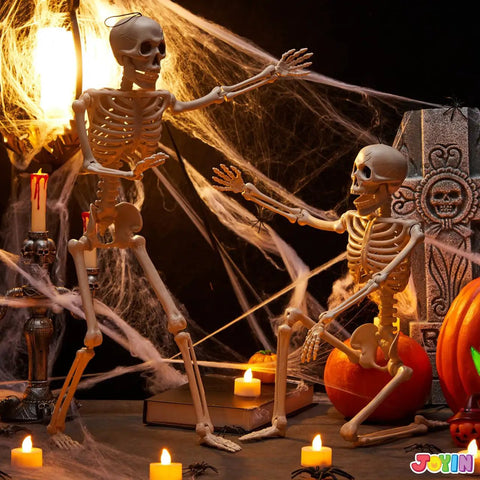 Two Pack 24 Inch Full Body Poseable Skeletons with Locking Joints beside cobwebs and candles for Halloween decor