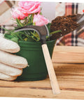 Multipurpose Manganese Grass Sickle With Handle Ergonomic Gardening Tool next to potted plant