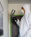 Person using Beast Workhorse HVLP Gravity Feed Paint Sprayer With 1.7 mm Nozzle 600 CC Air Regulator All Steel Body indoors.