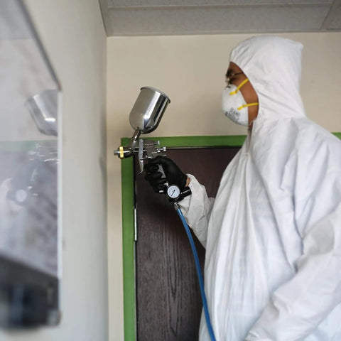 Person using Beast Workhorse HVLP Gravity Feed Paint Sprayer With 1.7 mm Nozzle 600 CC Air Regulator All Steel Body indoors.
