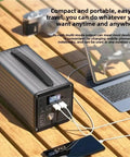 Heavy Duty Portable Power Station 220V Solar Generator With Multi Outlets Compact Backup Energy Kit Trail Ready For Campouts Road Trips Black on wooden table.