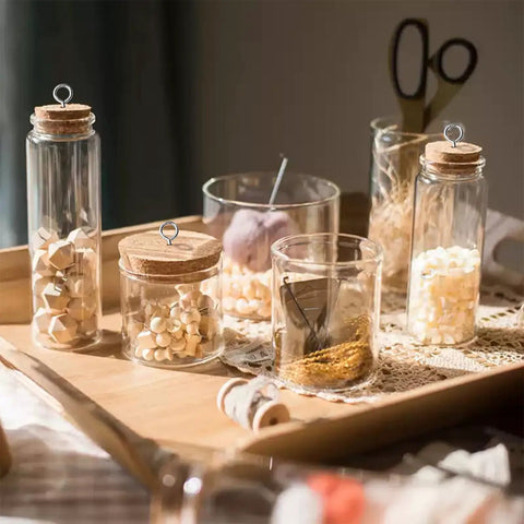 Glass jars with cork lids and Heavy Duty 2 Inch Screw Eyes Set In 304 Stainless Steel on a wooden tray.