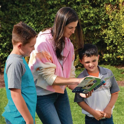Adult and two children reading instructions for Extreme Geyser Tube Science Kit For Kids With Mentos And Soda Lab Experiment Includes Tube Candy And Unique Spray Caps To Create Turbo And Triple Cap Eruptions For Chemistry Magic In The Classroom STEM Project