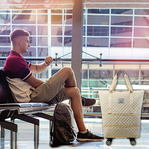 Front view of a white quilted rolling duffle bag with wheels and carrying handles, carry-on size (Amazon).