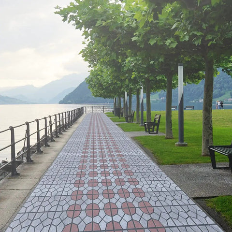 Scenic outdoor path made with Two Pack Easy To Use DIY Concrete Molds And Forms For Garden Walkways And Patios 15.7 Inch Square 1.6 Inch Thick Reusable Cement Molds For Pathway Pavement Stepping Stones Outdoor Yard Patio, lined with trees by a lake.