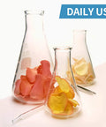 Must Have Three Piece Glass Erlenmeyer Flask Set With Rubber Stoppers And Precise Scales Borosilicate Lab Flasks In 250ml 150ml And 50ml For Chemistry Labs, Experiments, And Science Studies, filled with flower petals.