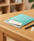 Teal 5x6 Inch Poly Bubble Mailers With Self Seal Adhesive Waterproof Padded Shipping Bags for Small Biz Packing on wooden desk