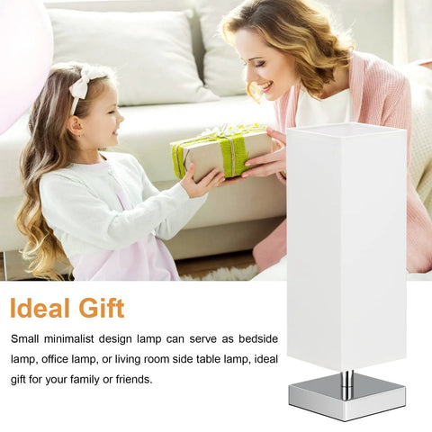 Cozy Minimalist Table Lamp For Bedroom Bedside Nightstand With Square Fabric Shade, Desk Reading Light For Kids Room Living Room Or Office, White Shade And Silver Base, UL Listed in a stylish room with gift-giving scene