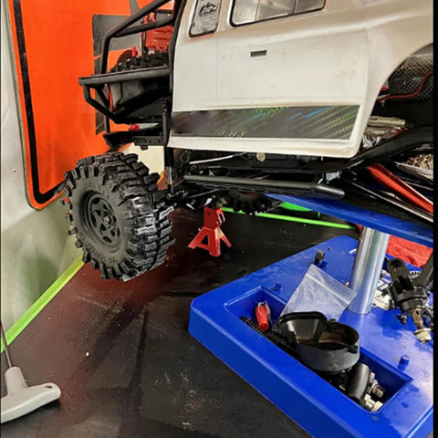 Four red metal 3/6-ton RC jack stands for 1/10 scale crawlers, shown lifting a D90 Axial Wraith SCX10.