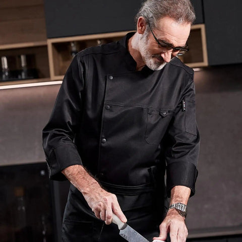 Chef wearing Heavy Duty Chef Coat With Chest And Sleeve Pocket Plus Hella Breathable Fabric That Keeps You Cool In The Heat Top Drawer Restaurant Cook Uniform while chopping.