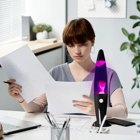 Person studies papers beside Purple Liquid Motion Lamp For Adults And Kids Magma Motion Lamp With White Wax Flows Glass Nightlight
