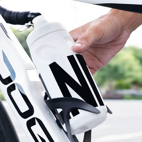 Leak Resistant Squeeze Lid Water Bottle For Biking And Hiking being placed in bike cage