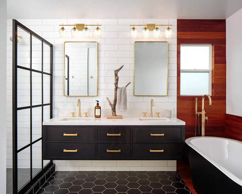 Industrial 4 Light Vanity Fixture with Clear Glass Bath Wall Sconces in Dope Gold Finish above modern vanity mirrors.