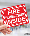Close-up of hand holding "Fire Extinguisher Inside" bright red vinyl decal for cars, trucks, RVs, and other vehicles.