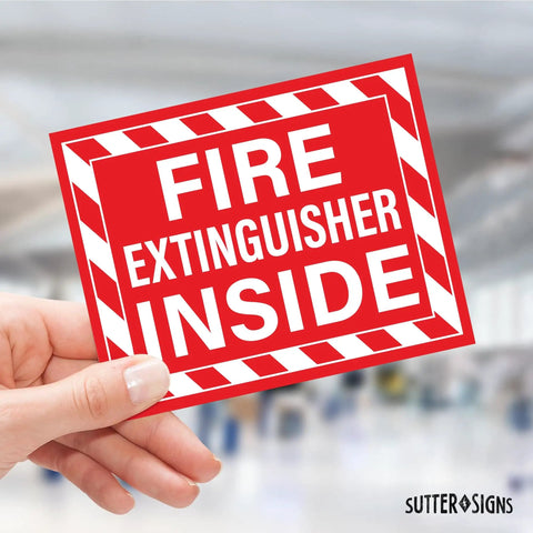 Close-up of hand holding "Fire Extinguisher Inside" bright red vinyl decal for cars, trucks, RVs, and other vehicles.