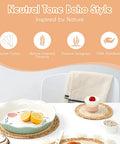 Neutral tone boho style kitchen items with seagrass placemats, a ceramic plate, and dessert bowl on a white table.