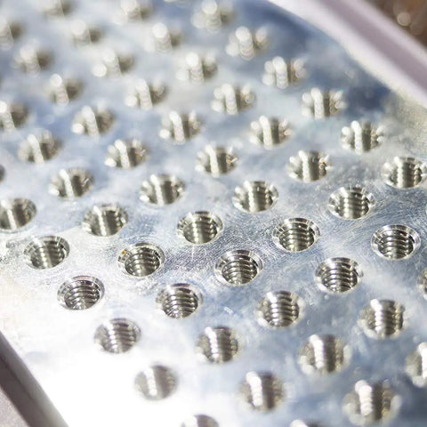 Close-up of metal plate with threaded holes for Spiral Point Threading Tap M6 X 1.0 With H2 Tolerance TICN Coated High Speed Steel