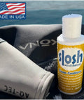 Slosh Wetsuit Cleaner And Conditioner For Water Sports Gear, Naturally Green Formula, Safe On All Wetsuits And Neoprene, Cleans And Conditions Without Harsh Chemicals, 4 Ounce Bottle with American flag label, wetsuit background