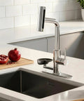 KAIYING Waterfall Kitchen Faucet with Pull Down Sprayer & Glass Rinser beside pomegranate on countertop.