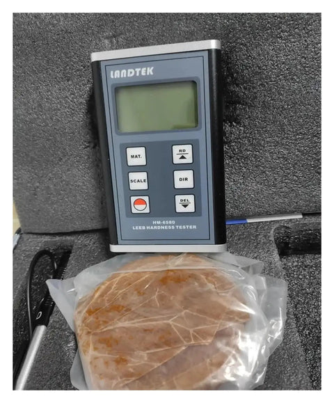 Super Handy Portable Digital Leeb Hardness Tester Durometer Sclerometer displaying readings with test sample on a case.