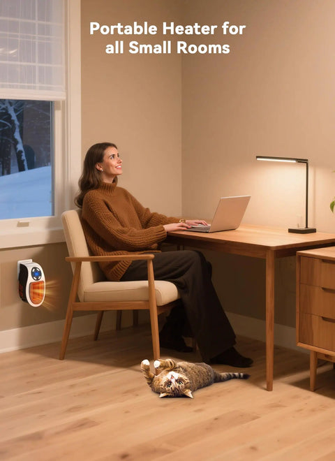 Woman working in home office with Power Saving 450W Space Heater With Remote Wall Outlet Plug As Seen On TV on wall, cat resting nearby.