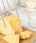 Heavy Duty Stainless Steel Cheese Slicer Wire And Y Type Cutter With Twist Lock Kitchen Workhorse For Cheese Boards And Meal Prep No Drama Total Game Changer Dishwasher Safe cutting through cheese block.