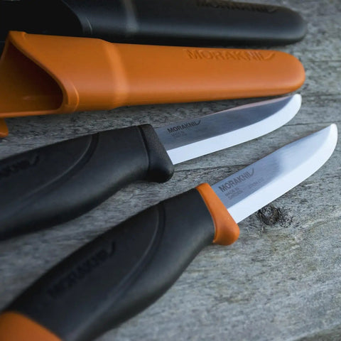 Heavy Duty Outdoor Knife With A 4.1-Inch Stainless Steel Blade And Bright Orange Handle on wooden surface, close-up.