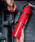 Slick Under Seat Fire Extinguisher Bracket For Ineos Grenadier Truck With One Hand Quick Release Aluminum Mount Kit and Heavy Duty Secure Ratchet Straps, close-up of fire extinguisher mounting