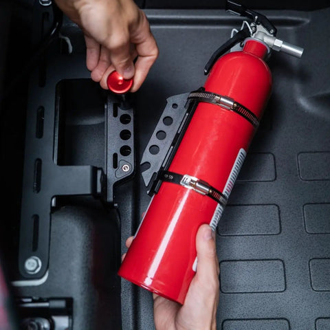 Slick Under Seat Fire Extinguisher Bracket For Ineos Grenadier Truck With One Hand Quick Release Aluminum Mount Kit and Heavy Duty Secure Ratchet Straps, close-up of fire extinguisher mounting