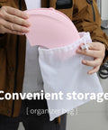 No Sweat Portable Potty For Toddler Pink Travel Training Seat being stored in a white organizer bag for easy transport.