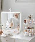 Two Tier Clear Rotating Vanity Organizer With Smooth 360 Degree Spin For Skincare And Perfume Beauty Essentials Storage on a bathroom countertop.