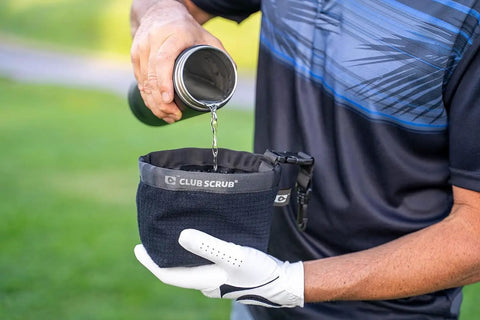 Person pouring water into Golf Club And Ball Cleaning Bag With Waterproof Liner And Clean Face Technology, black color.