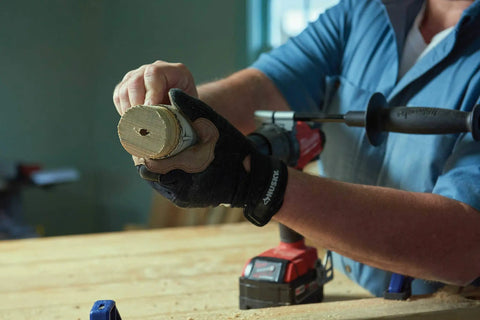 Person using 13 Piece Hole Saw Set With Quick Change Arbor And Quickcore Technology For Up To 10X Faster Core Ejection, Includes 3/4 Inch To 2 1/2 Inch Saw Sizes With Open Back Arbors For Easy Visibility in woodwork.
