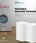 Stack of 60 white cotton terry towels 14x17 inches next to a washing machine for kitchen, bar, and restaurant cleaning use.