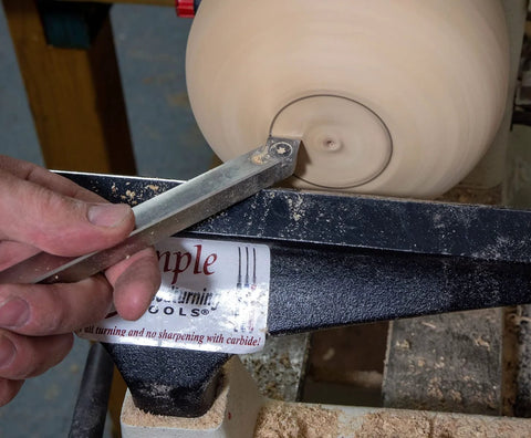 Carbide 90 Detailer wood lathe turning tool, stainless steel, unhandled, held in hand while shaping spinning wood