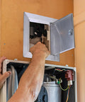 Person accessing Built Like A Tank 12 By 12 Inch 304 Stainless Steel Access Panel for plumbing maintenance.
