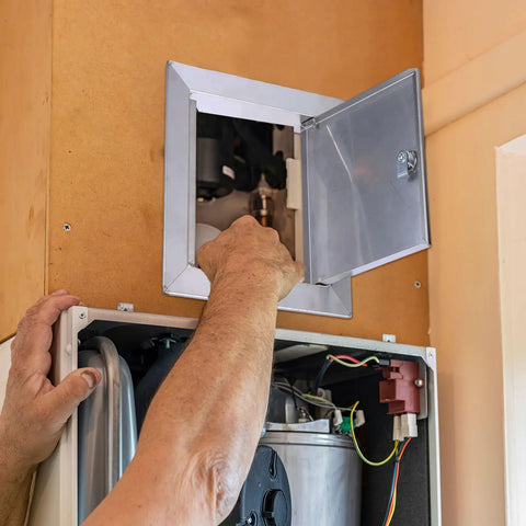 Person accessing Built Like A Tank 12 By 12 Inch 304 Stainless Steel Access Panel for plumbing maintenance.